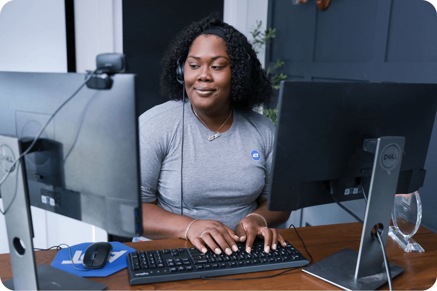 A customer service rep answers phone with headset and types on keyboard
